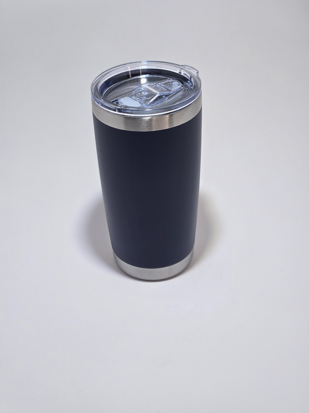 A sleek black insulated tumbler with a clear lid on a white surface.