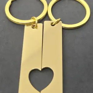 Two gold keychains with interlocking heart design.