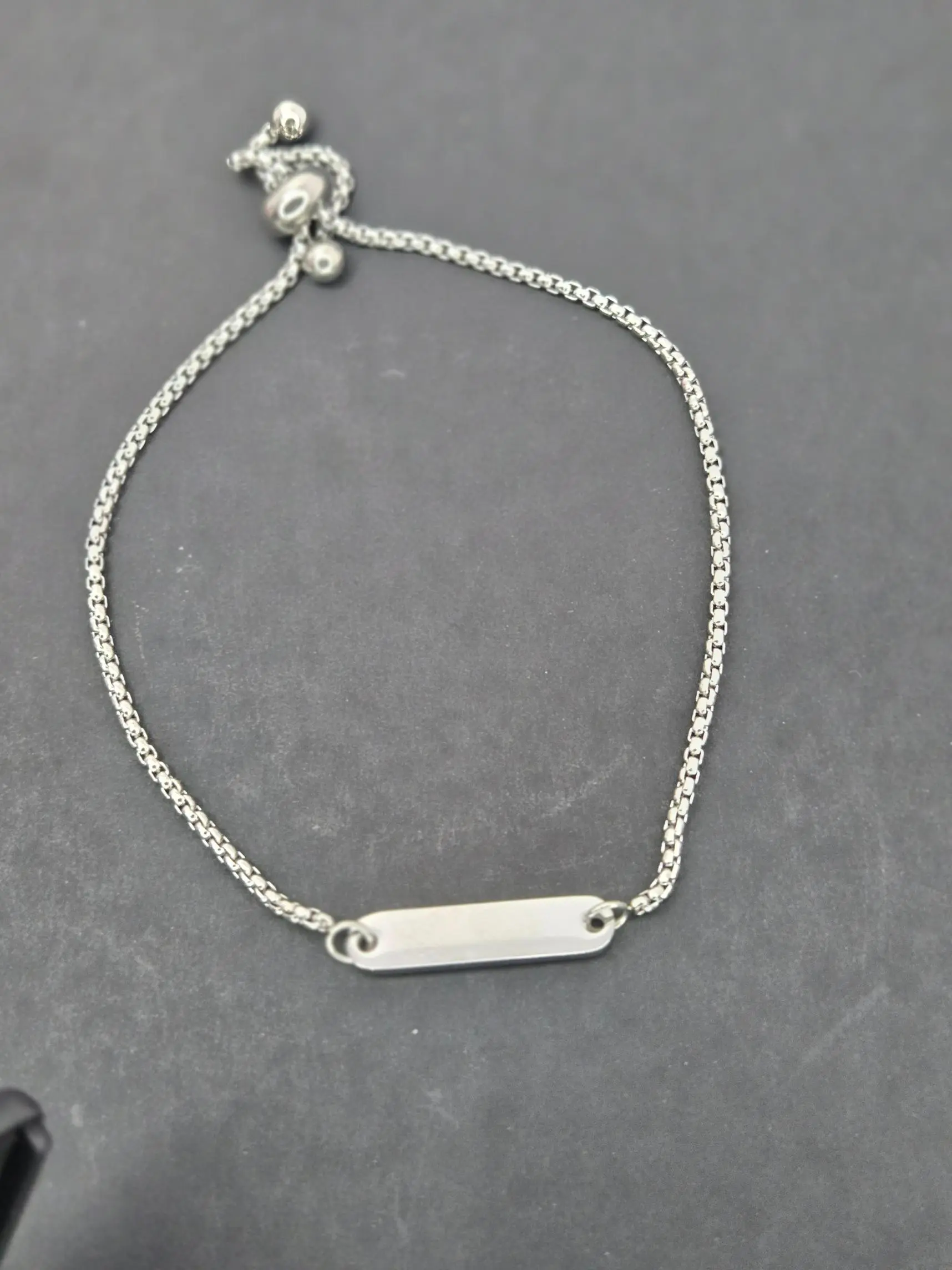 Elegant silver bracelet with a sleek bar charm.