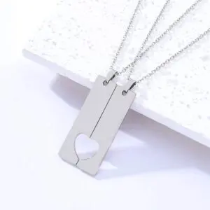 Two silver necklaces with heart-shaped cutouts on rectangular pendants.