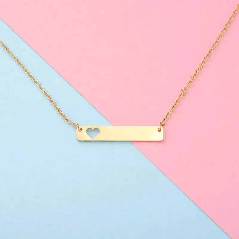 Gold necklace with a rectangular pendant and a small heart detail.