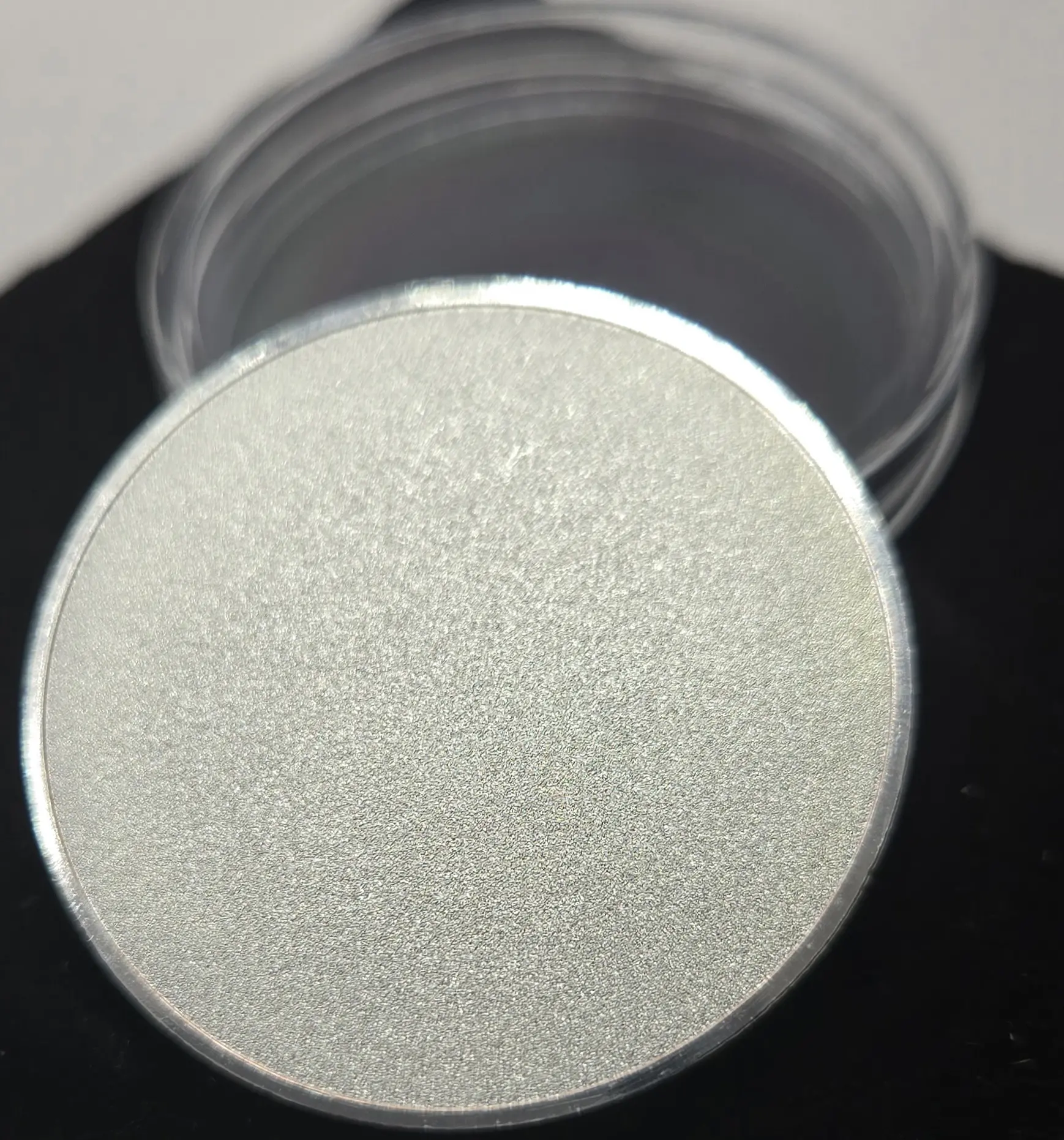 Close-up of a round, textured silver container lid.
