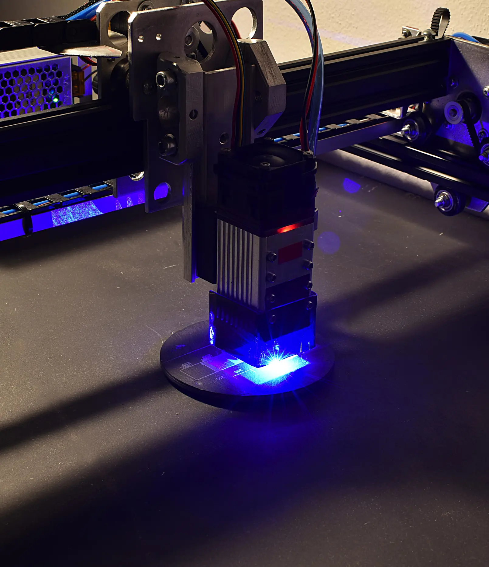 Laser engraving machine in action with bright blue light.