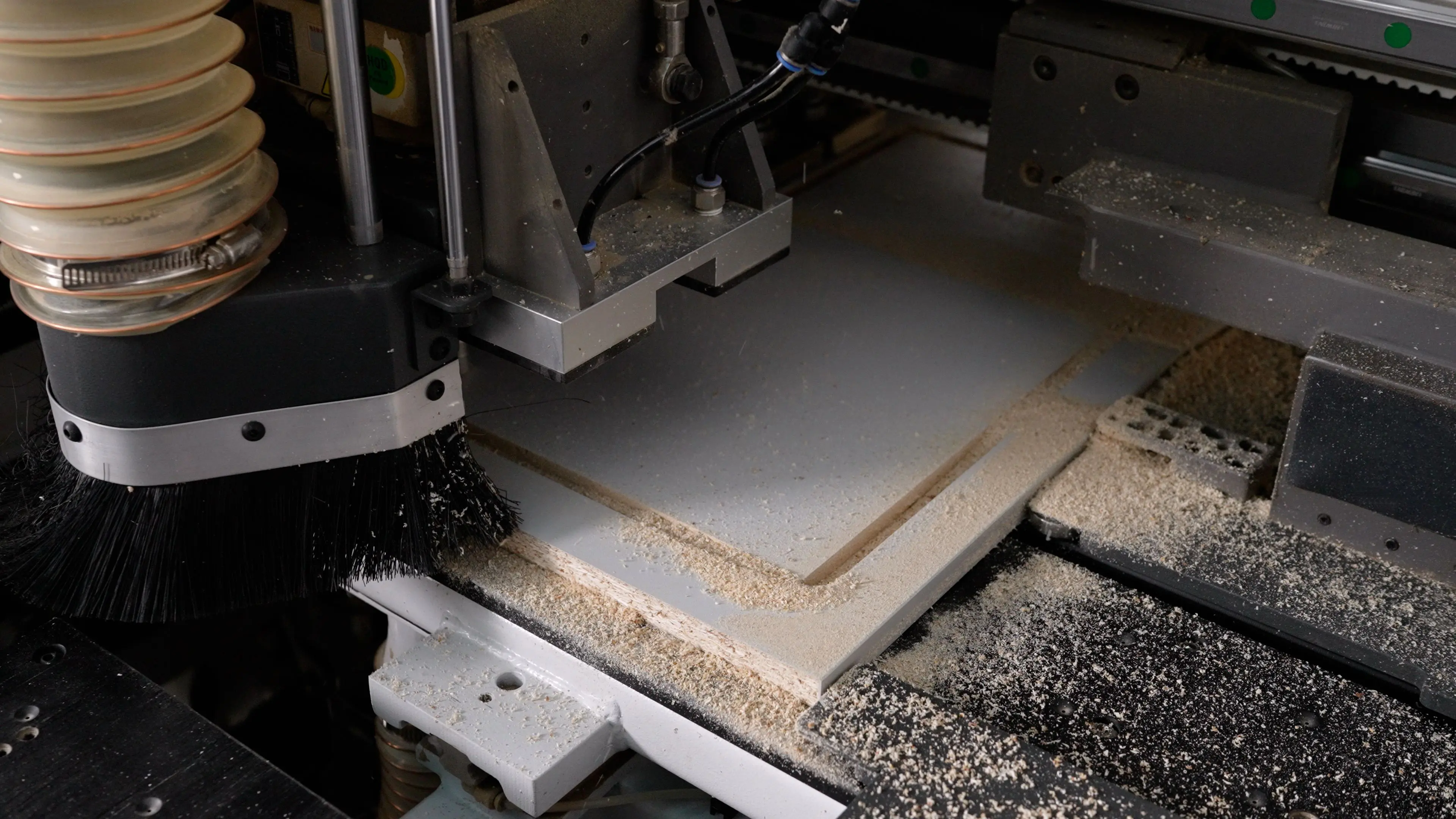 A CNC router cutting a rectangular shape out of wood.