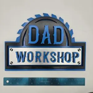 A blue and black sign saying 'DAD WORKSHOP' above a ruler.