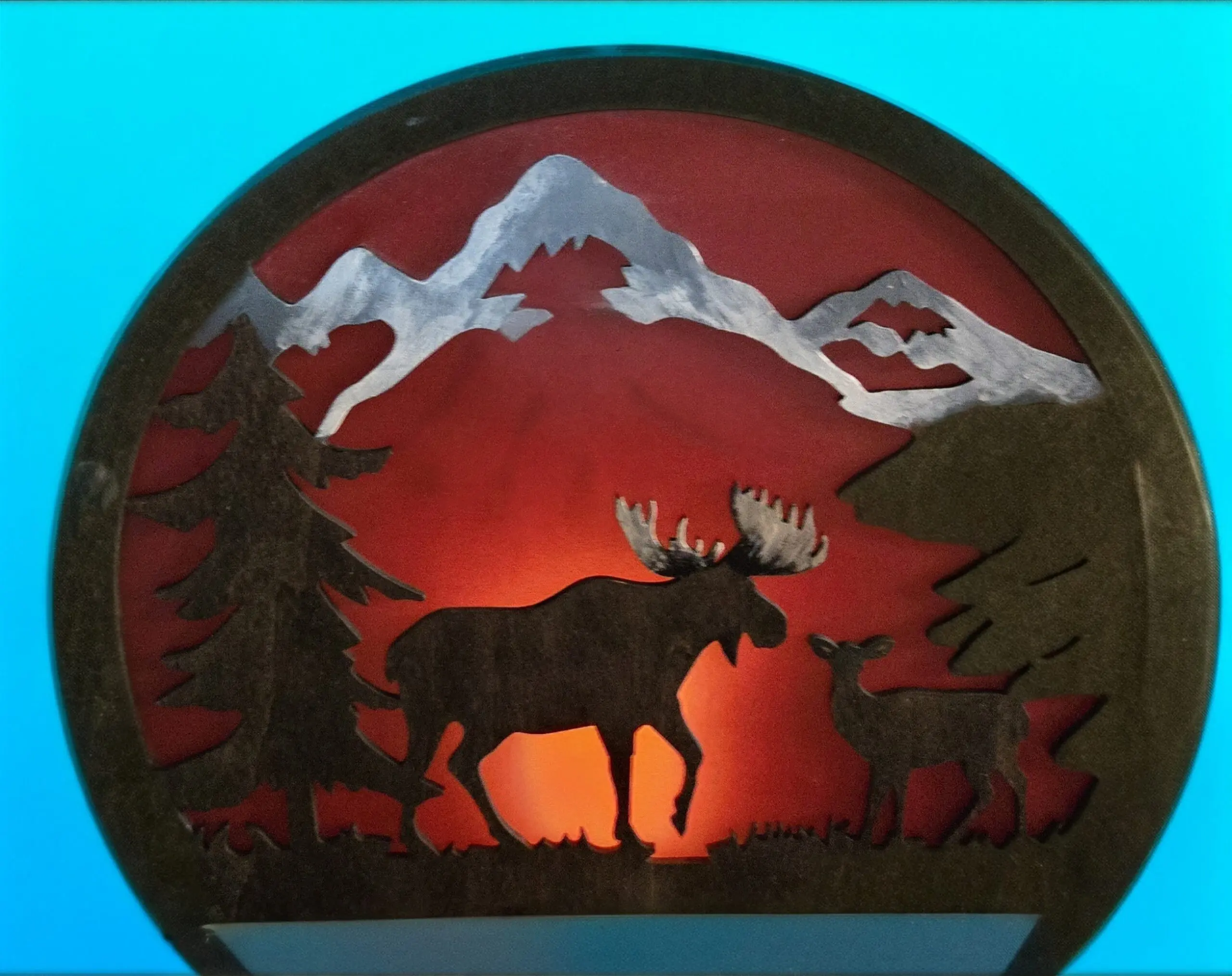 Backlit metal moose and calf mountain silhouette