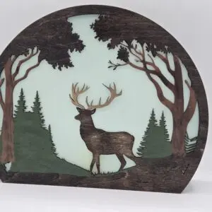 Round wooden deer silhouette amid trees