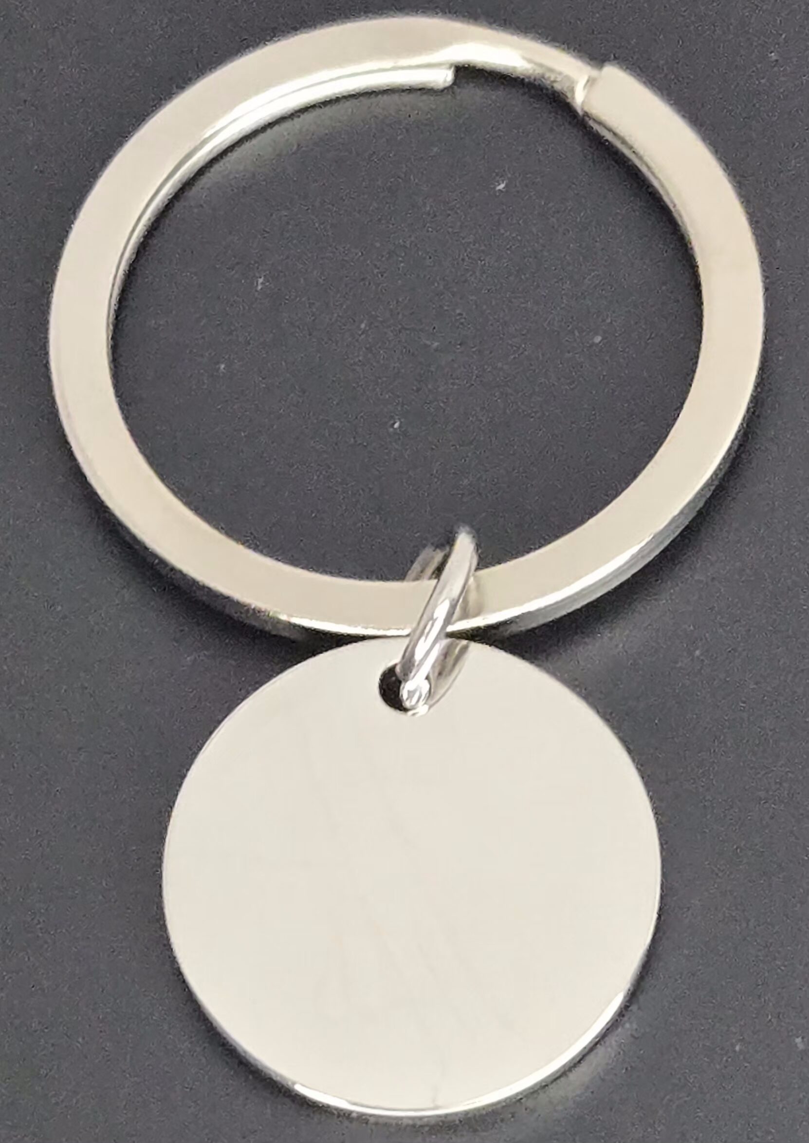A simple round metal keychain with a blank circular tag.
